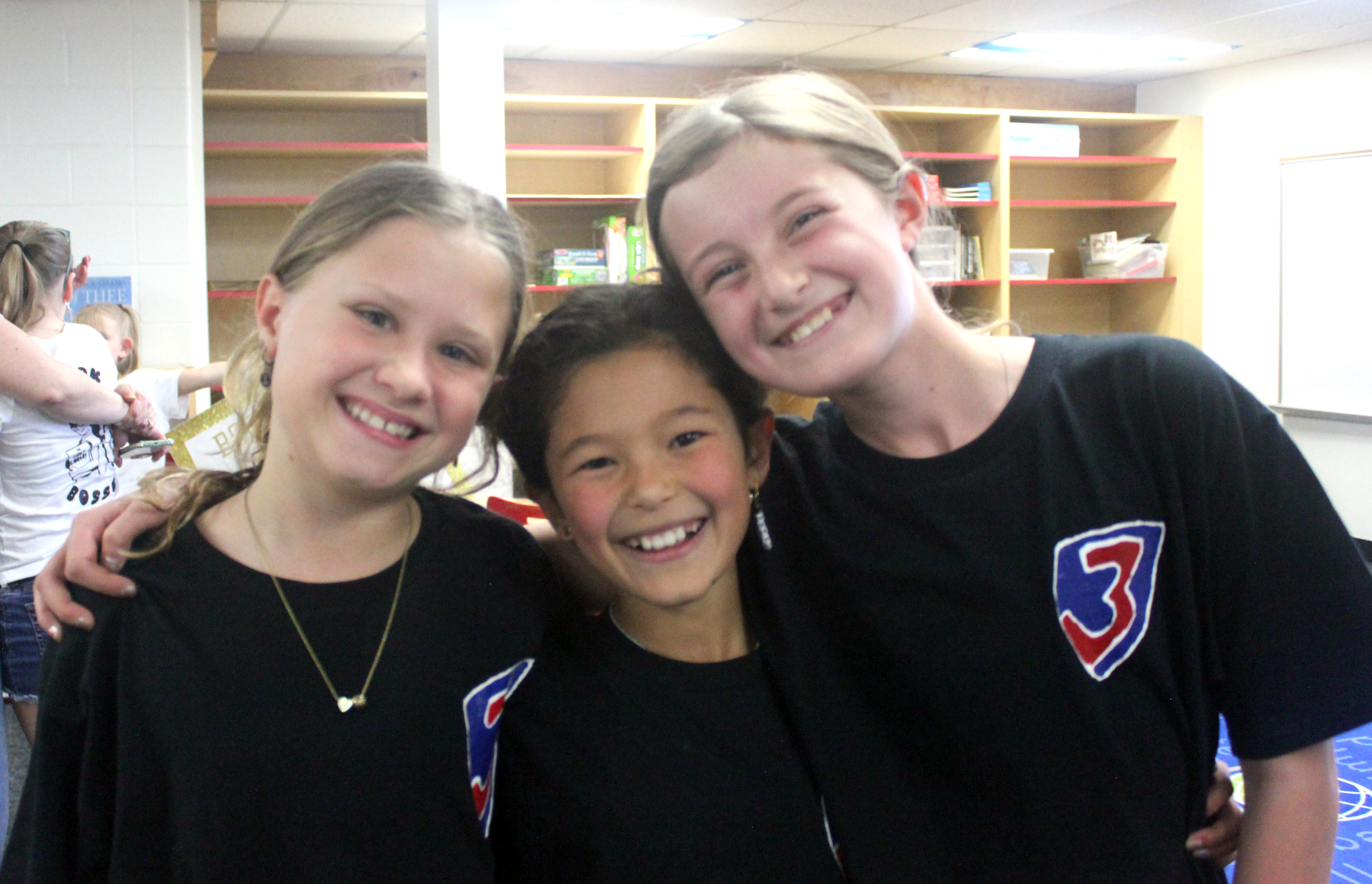 three girls with arms around shoulders - winners of grade 4 BOB competition
