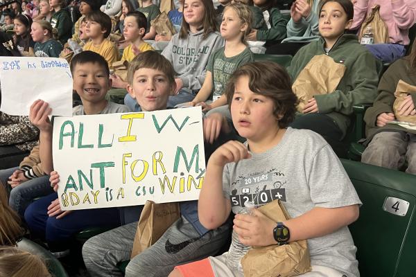 three boys hold a sign "all I want for my birthday is for csu to win" another boy holding sign "it's his birthday" 