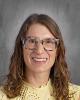 headshot - smiling female teacher long dark hair, wearing glasses, wearing yellow top
