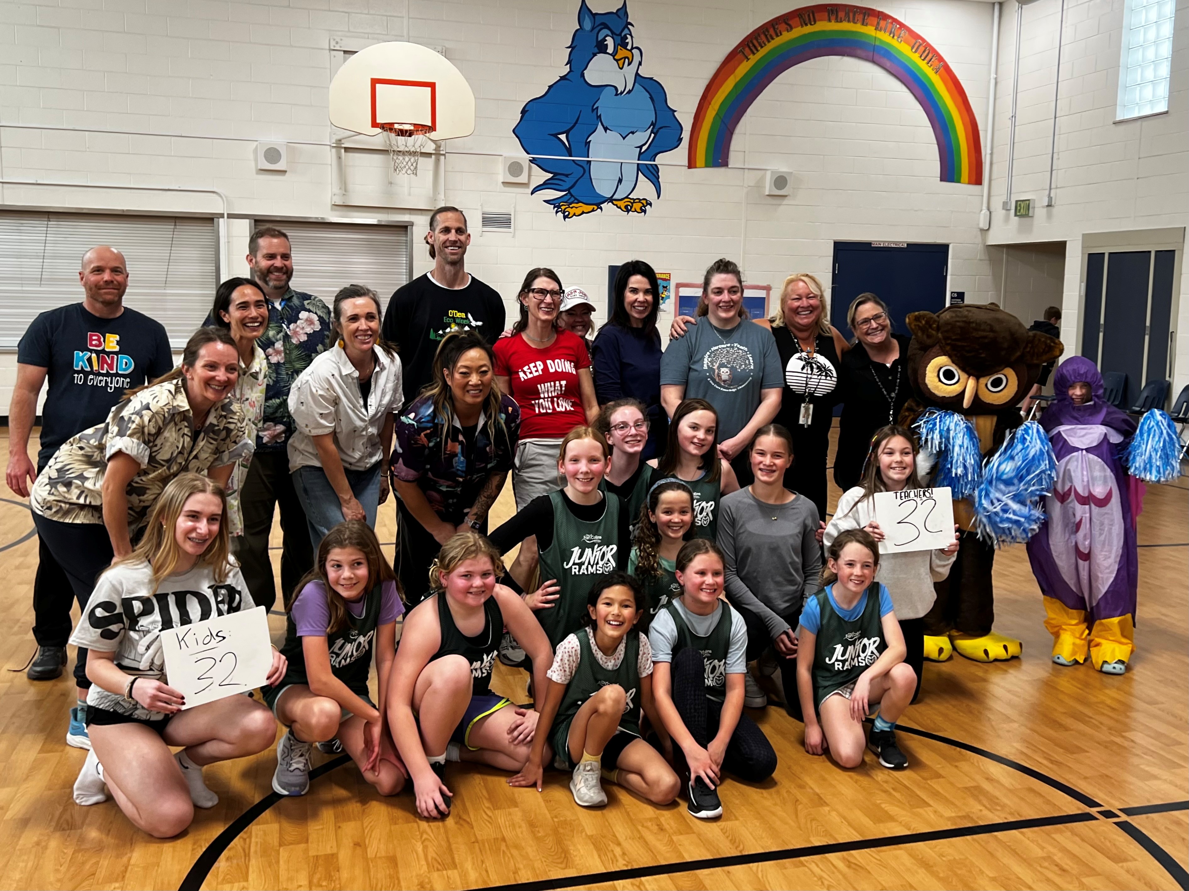 school staff and 4th grade girls basketball game photo - everyone smiling - along with school owl mascot in costume