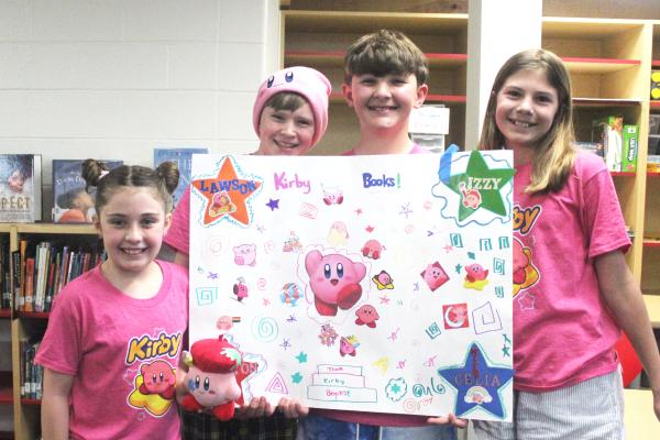 four students ( girl, boy, boy, girl) holding a poster for battle of the books