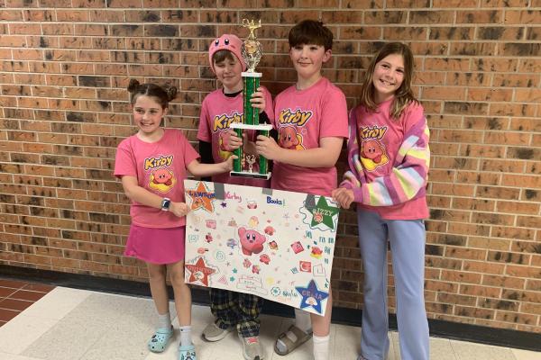 girl boy boy girls holding a team kirby poster and battle of the books 5th grade trophy