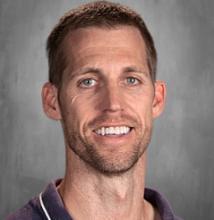 headshot - male teacher smiling short dark hair scruffy beaded chin