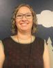 smiling female teacher in a sleeveless black top